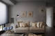 
                                    暖灰色调的沙发背墙缀饰风格掛画、造型时鐘与阅读灯，简约中可见设计品味。