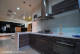 
                                    明亮且精緻时尚的L型开放式厨房，以水晶木皮面板的优雅线条与客厅风格相呼应。