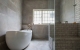 
                                    浴缸区大面积以板岩砖呈现，淋浴区则使用复古砖，界定出不同的机能领域。