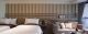 
                                    纵长的墙面以日式格栅串连卧床区与客厅。