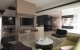 
                                    咖啡色电视墙、秋香绿沙发与白色烤玻不绣钢桌组合出多元的空间配色，使客厅气氛更显活泼。