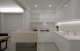 
                                    白色基底的厨房空间，半开放式的设计维持良好通风度，而吧台下方镜面贴覆有著反射、放大餐厅巧用。